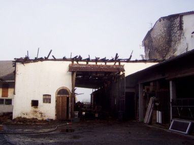 Blick auf die bis auf die Grundmauern abgebrannte Scheune und das angrenzende Wohnhaus